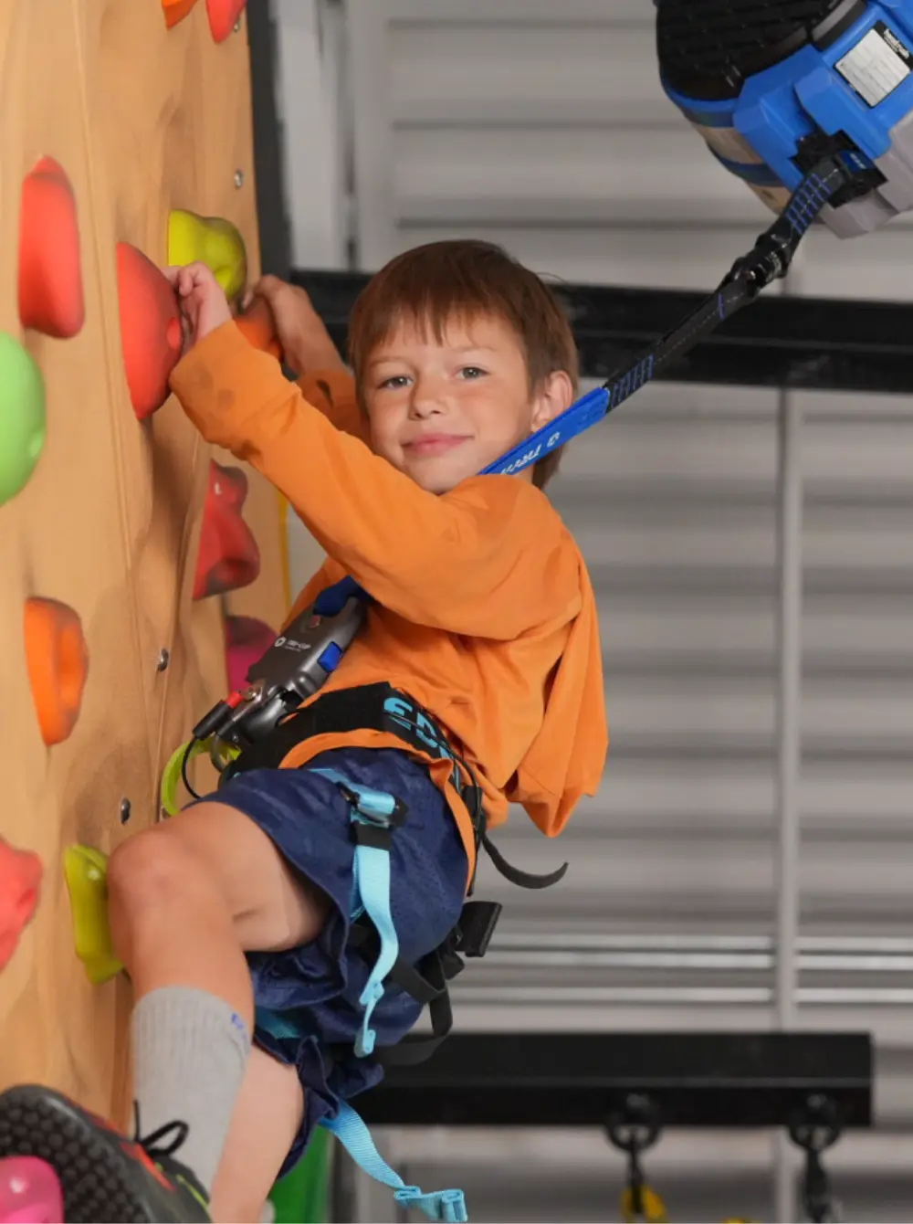Een klimmer die veilig afdaalt met behulp van een auto belay systeem op een indoor klimmuur