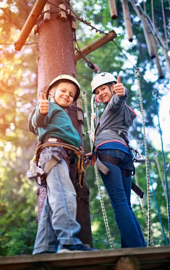 Bezoeker aan een activiteitstoestel in een klimpark met verplichte persoonlijke beschermingsmiddelen