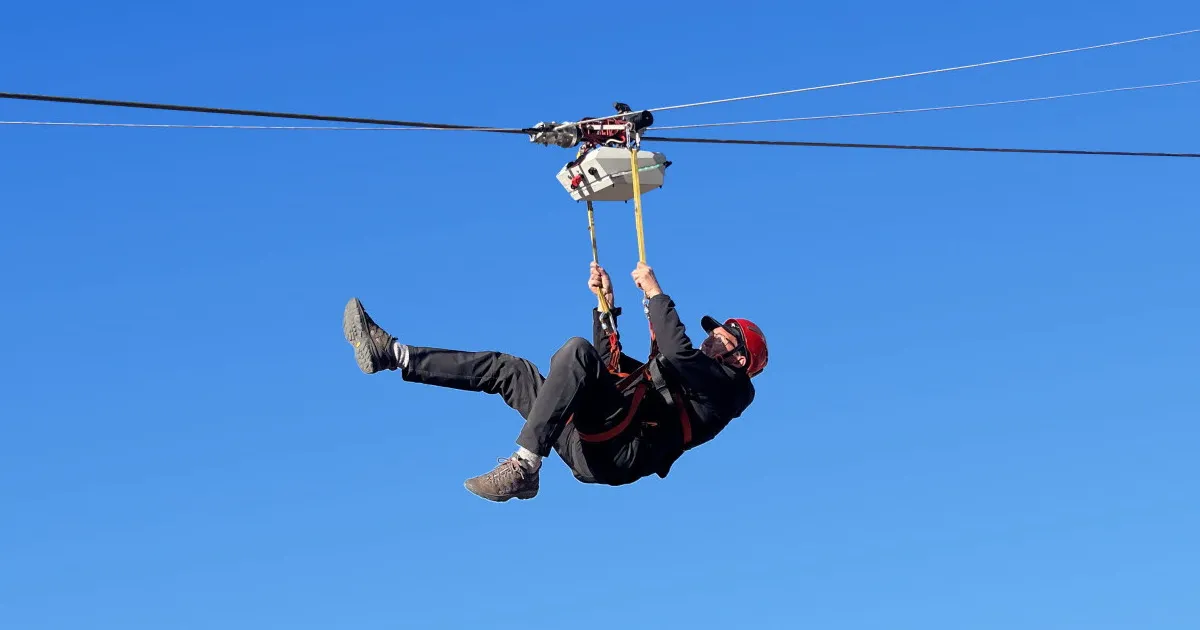 ZipTronik bi-directional zipline trolley with self-regenerative charging in operation on a downhill descent