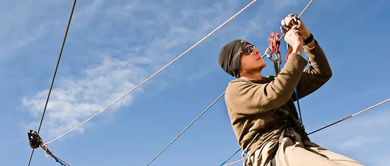 Een getrainde professional voert inspectie uit aan de hardware van de zipline